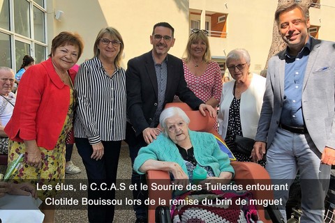 Les élus, le C.C.A.S et le Sourire des Tuileries entourant Clotilde Bouissou lors de la remise du brin de muguet